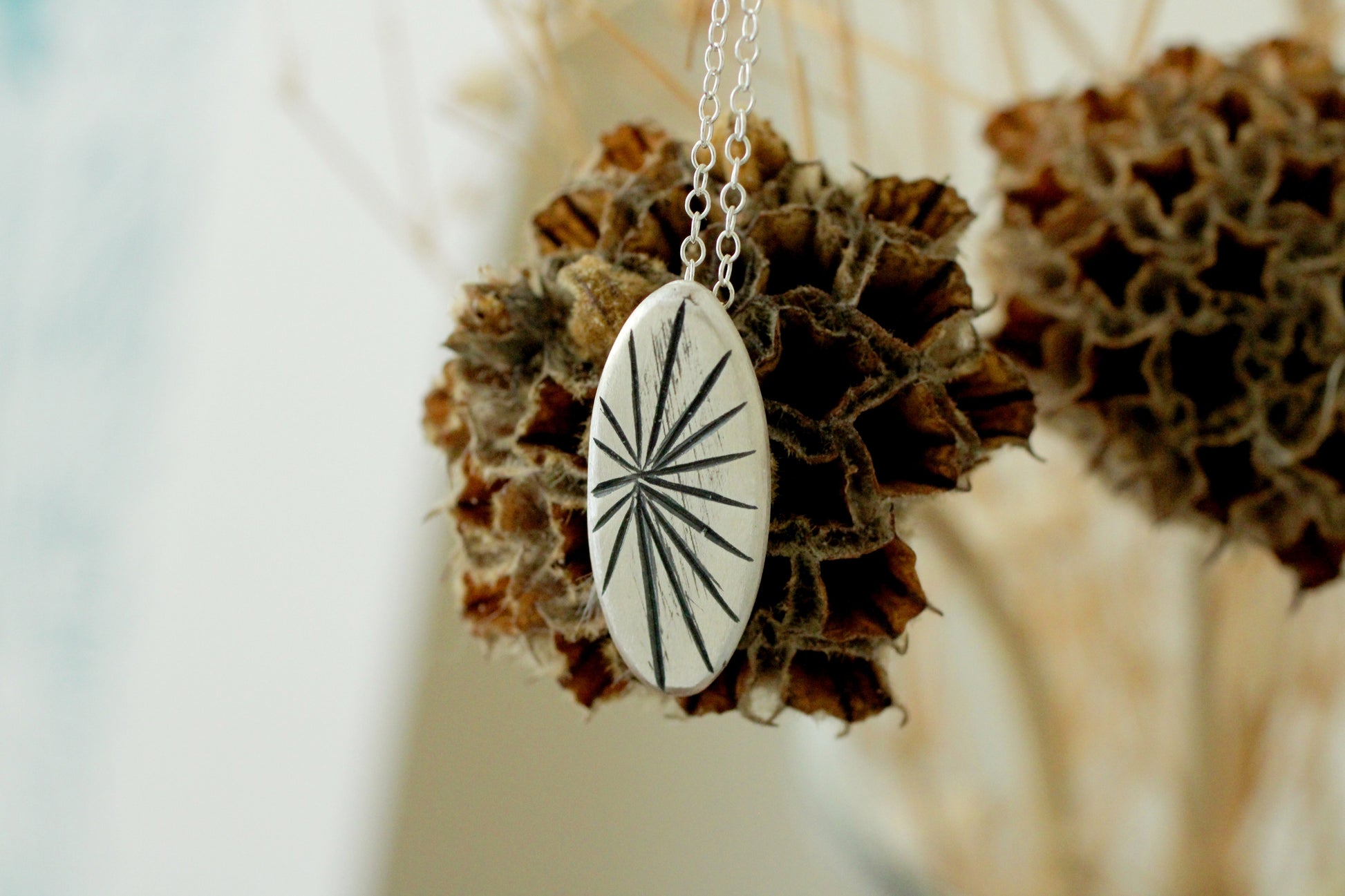 Silver necklace with a circular silver pendant with a line pattern engraved with oxidation finish